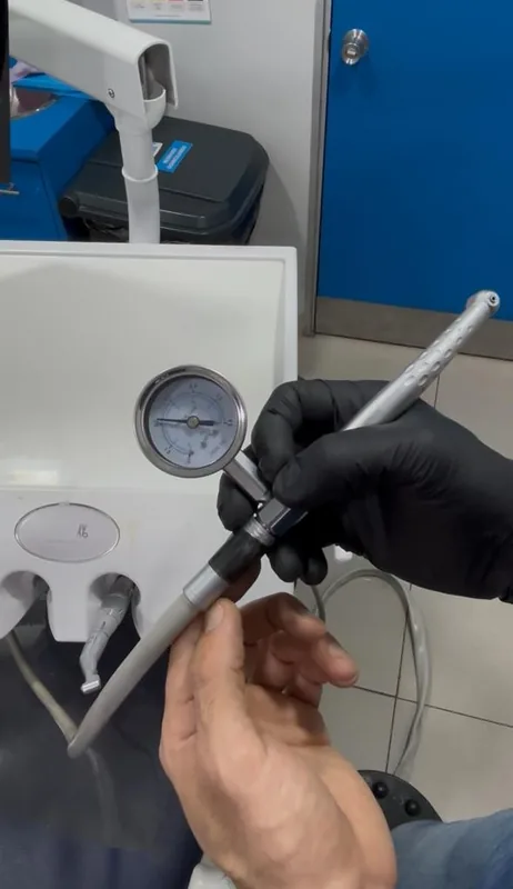 Técnico STD midiendo presión de compresor dental
