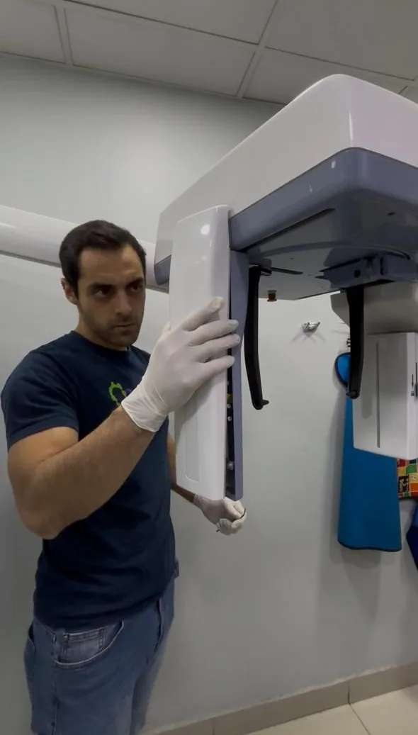 Técnico STD realizando mantenimiento de equipo panorámico dental en Santiago